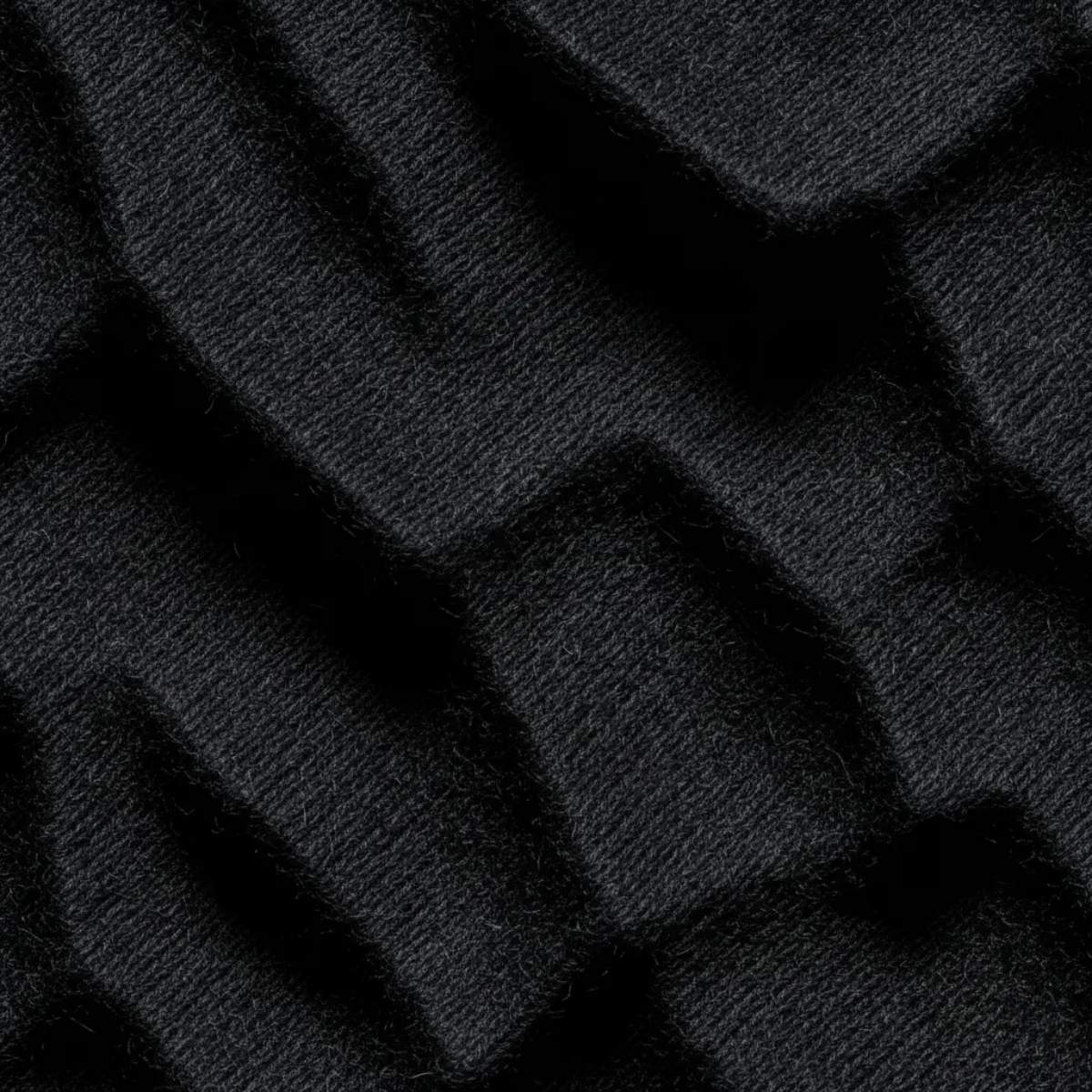 Dettaglio macro del tessuto Heavy Jersey nero 240g/m². Trama materica ad alta densità ispirata al rigore delle profondità di Oceania e alla forza della cultura Maori. Standard GL MANIFACTORY.