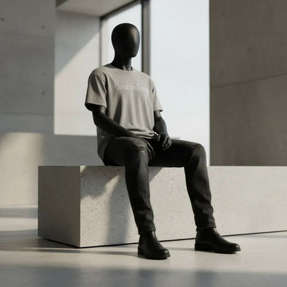Modulo Herekoretanga: maglia grigio asfalto con lavaggio acido su manichino in ambiente brutalista. Estetica minerale ispirata alle formazioni rocciose di Oceania e alla forza Maori. Design GL MANIFACTORY.
