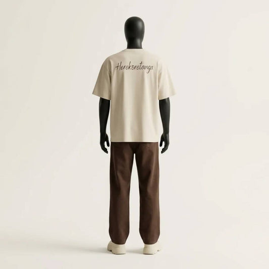 Modulo Herekoretanga: prospettiva posteriore maglia color sabbia 240g/m² su manichino tecnico nero. Studio del volume boxy con grafica "Herekoretanga" ispirato al rigore di Oceania e alla forza della cultura Maori. Architettura tessile GL MANIFACTORY.