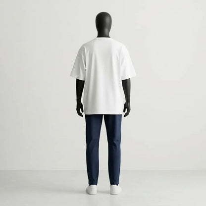 Analisi volumetrica posteriore del Modulo White. La caduta pesante del jersey bianco esalta il design strutturale GL MANIFACTORY, unendo l'essenzialità urbana alla simbologia ancestrale Maori