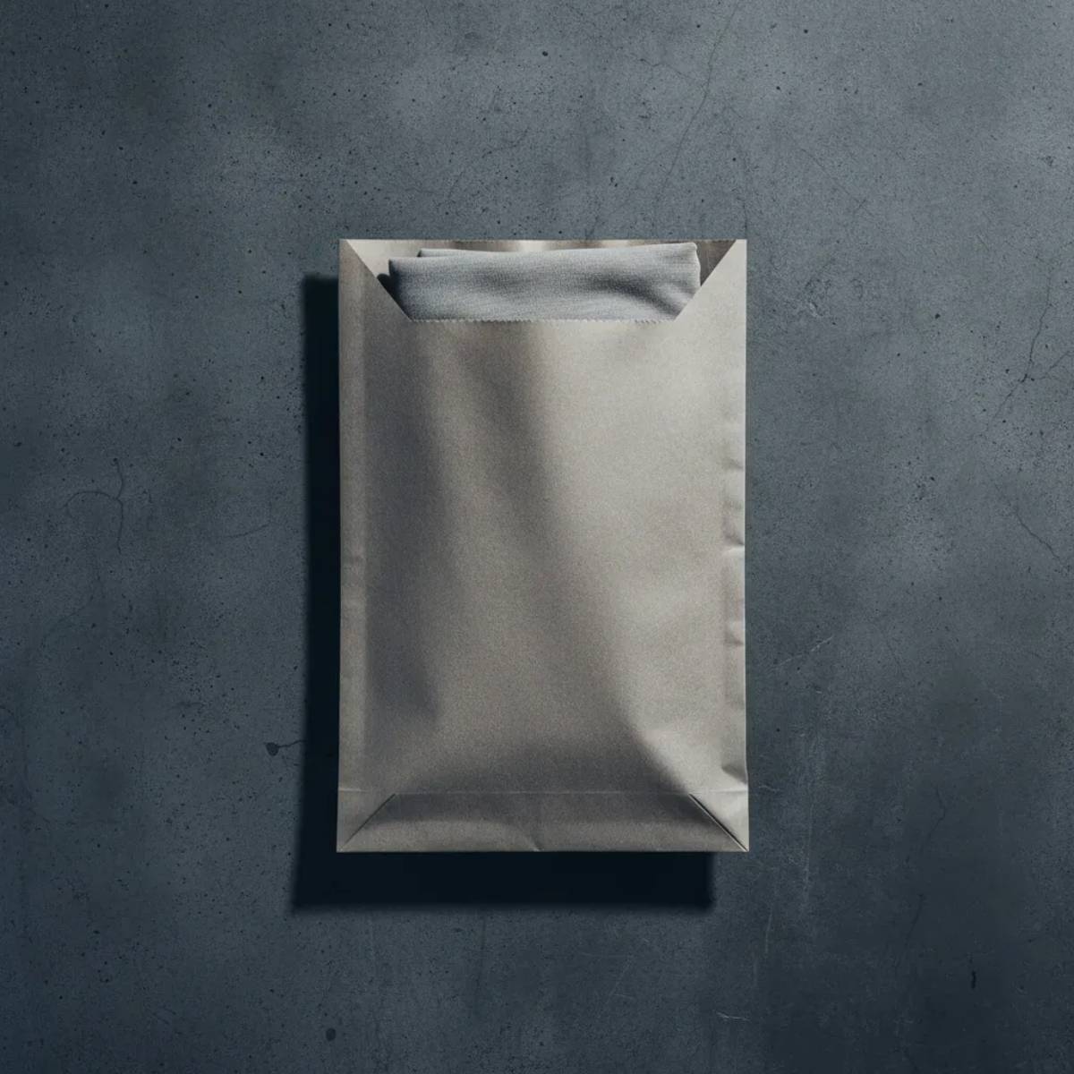 Packaging tecnico GL MANIFACTORY: modulo Herekoretanga inserito in busta eco-friendly su cemento. Protocollo di spedizione ispirato alla cura della materia in Oceania e alla tradizione Maori.

